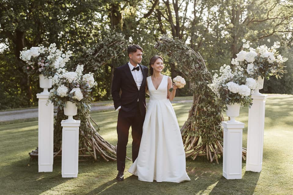 Bride and groom standins in a park