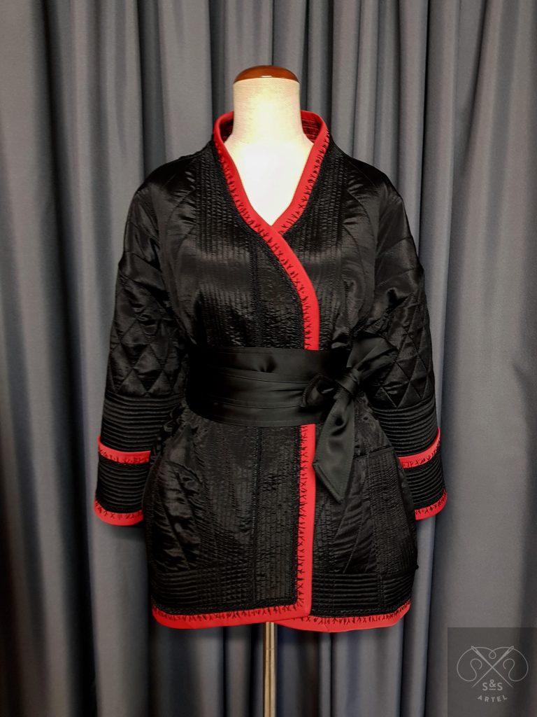 Black quilted jacket with red bias tape and black stitches