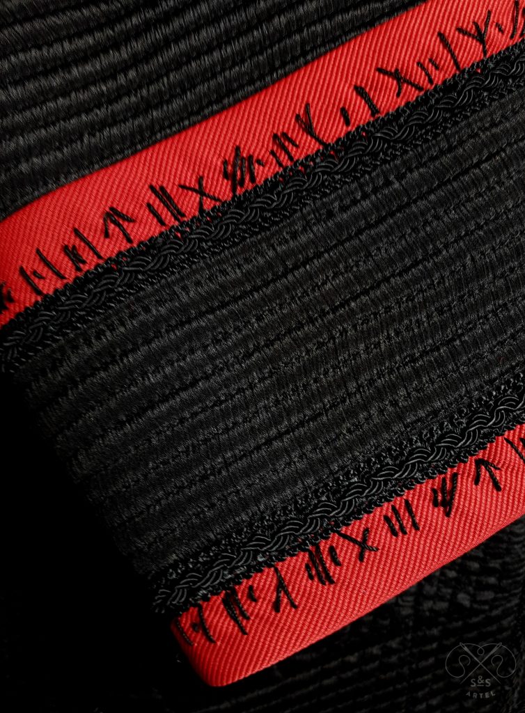 Black quilted jacket with red bias tape and black stitches
