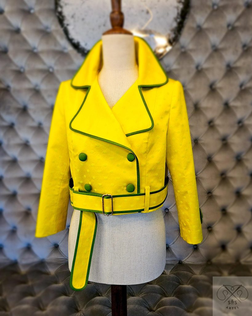Bright yellow trench style jacket with green tafeta bias tape